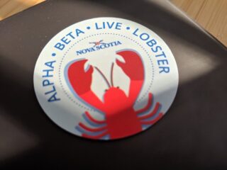 A sticker saying "Alpha, beta, live, lobster"